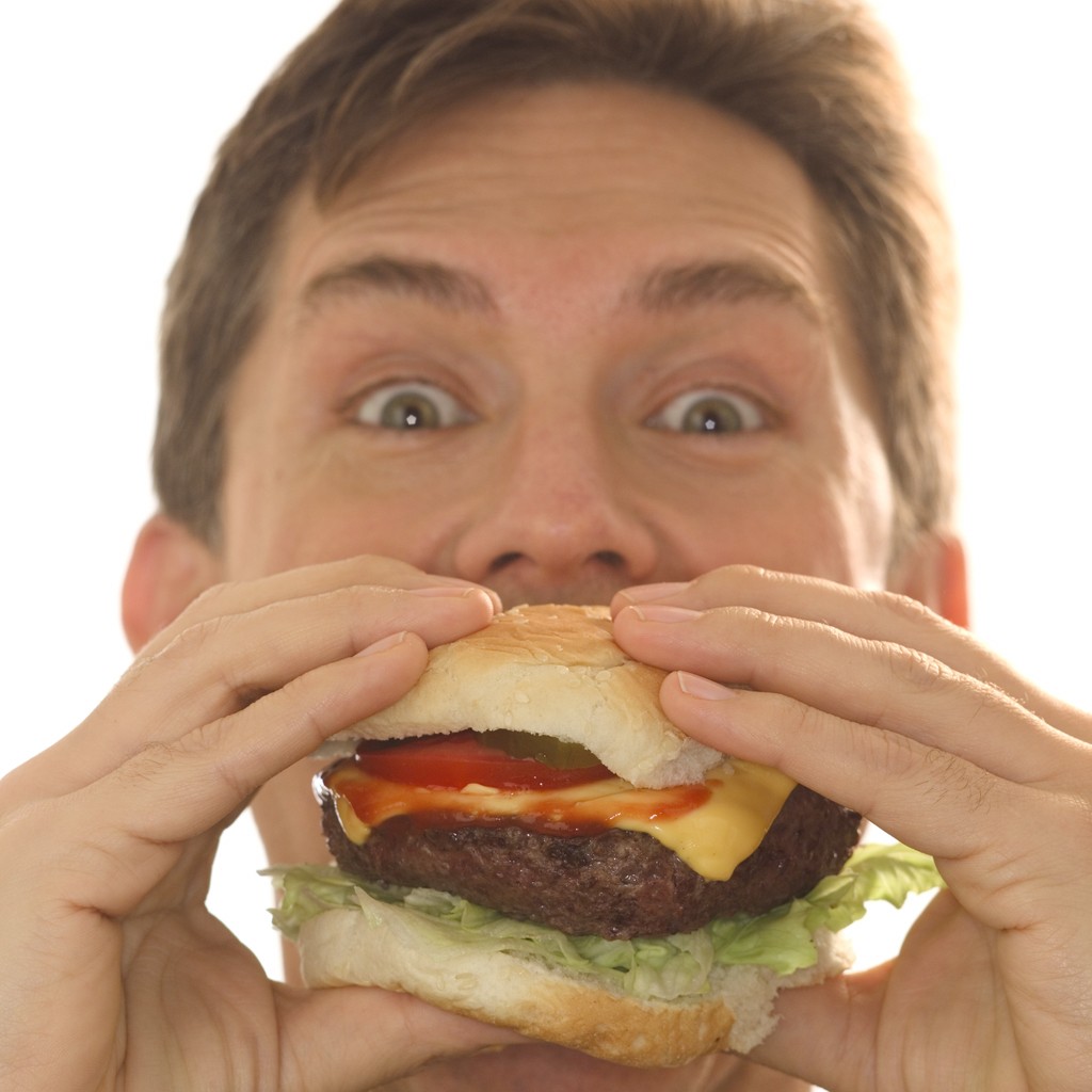 Держит еду во рту. Человек с едой. Человек ест бургер. Человек гамбургер. Гамбургер во рту.